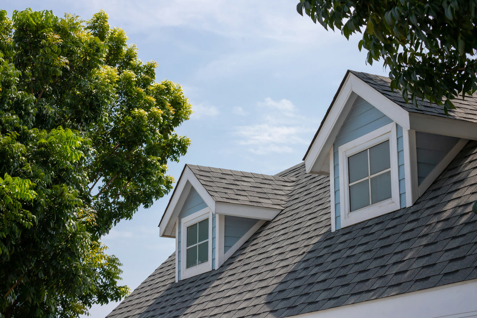 Close up view of new roof shingles on blue house